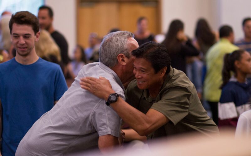 Two Dads hugging and discussing event