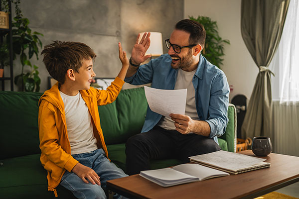 Dad high fives his son for doing well on his test
